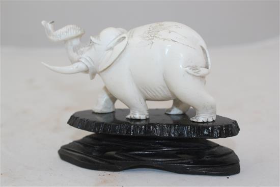 Ivory elephant on stand, a pair of bookends and two ivory bead necklaces